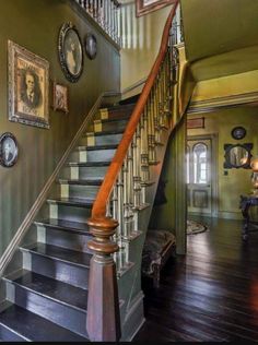 a staircase with pictures on the wall and wooden steps leading up to an entryway