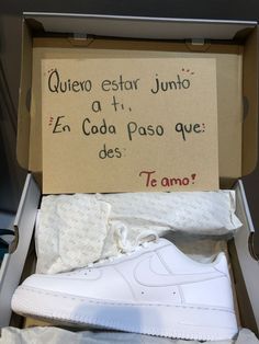 an open shoe box with some white shoes in it and a sign that says, quiero estar juito at 1 en coca paso que des