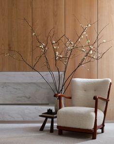 a chair and table in front of a wall with wooden paneled walls behind it