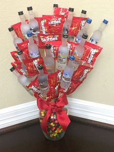 a vase filled with lots of different types of water and candies on top of a table