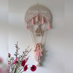 there is a wall decoration with pink flowers in the vase and a teddy bear hanging on the wall