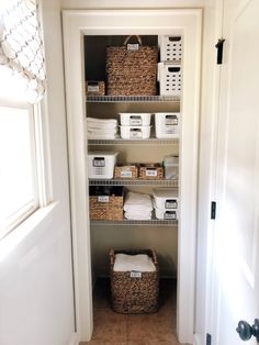 an organized pantry with baskets and towels