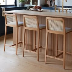 three stools sit at the center of a kitchen island