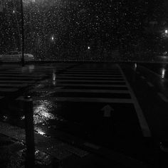 an empty cross walk in the rain at night