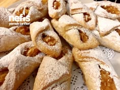 several pastries are piled on top of each other with powdered sugar and walnuts