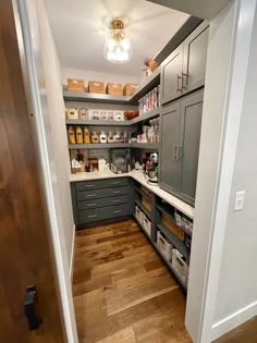 a kitchen with gray cabinets and wooden floors