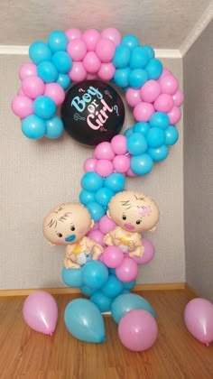 two babies are in the middle of balloons