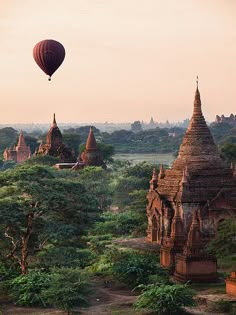 a hot air balloon flying over some temples