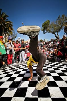 a man doing a handstand with a frisbee in front of a crowd