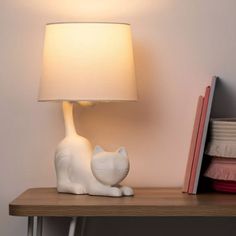 a white cat lamp sitting on top of a wooden table