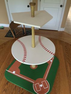 a baseball themed table with a base and ball on it, in the middle of a room