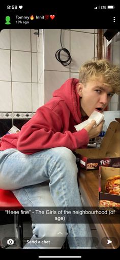 a person sitting on a red chair eating pizza