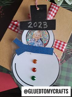 a snowman ornament with a photo on it