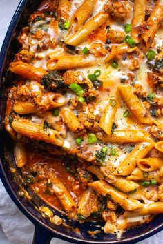 a skillet filled with pasta and meat covered in cheese