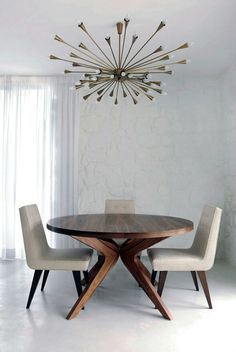 a dining room table with chairs and a chandelier hanging from it's ceiling