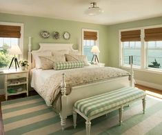 a bedroom with green walls and striped carpeted flooring, along with a white bed