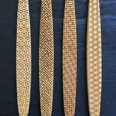 three carved wooden spoons sitting on top of a blue table next to each other