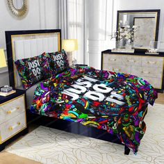 this is a bed with colorful comforter and pillows on it, along with two nightstands