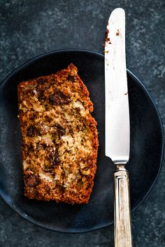 a piece of bread sitting on top of a plate with a knife next to it