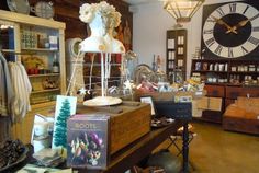 a room filled with lots of clutter and items on display in front of a large clock