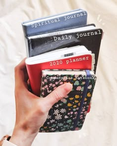 a person holding three books in their hands with the title'daily journal'written on them