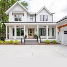 a large white house with lots of windows on it's front porch and stairs leading up to the entry door