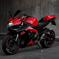 a red and black motorcycle parked in front of a building