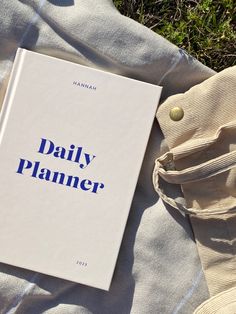 a book sitting on top of a white blanket next to a pair of pants and shoes