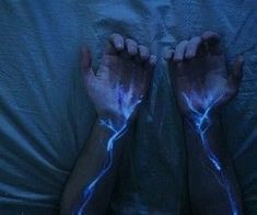 two hands with blue light painted on them are shown in the shape of lightnings