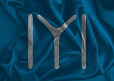 the letter y is made up of silver letters on a blue silk background with folds