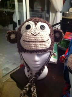 a crocheted monkey hat on top of a mannequin head