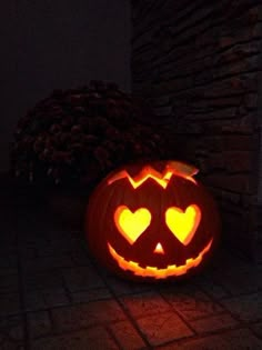 a pumpkin carved to look like a peace sign with heart cutouts on it's face