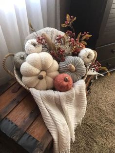 a basket filled with white pumpkins and other fall decorations on top of a wooden crate