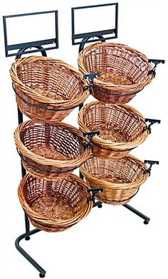 four wicker baskets are stacked on metal stands