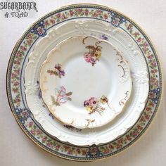 an antique china dinner plate with flowers on the rim and gold trim around the edge