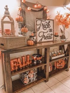 a wooden table topped with lots of pumpkins and other decorations on top of it