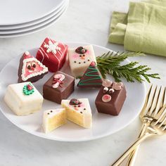 a white plate topped with lots of different types of cakes on top of a table