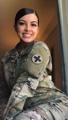 a woman in uniform is smiling for the camera