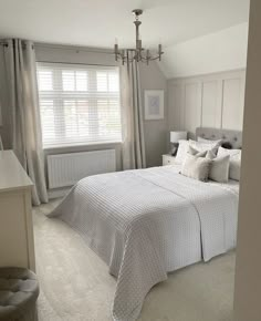 a bedroom with a large bed and white walls