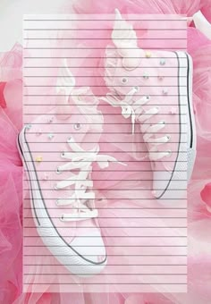 a pair of pink sneakers sitting on top of a lined paper with white laces