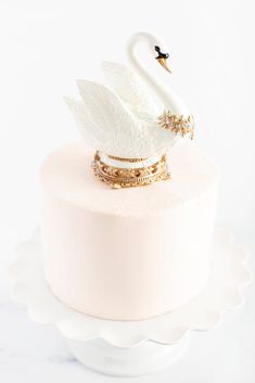 a white cake topped with a swan on top of it