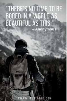 a person with skis walking up a hill in front of snow covered mountains and the quote there's no time to be bored in a world as beautiful as anonymous