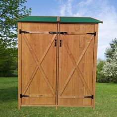 a large wooden storage shed sitting on top of a lush green field