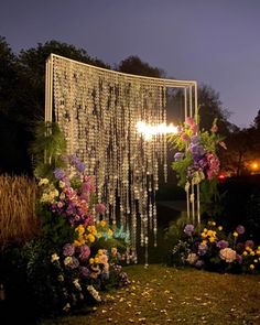 an outdoor wedding ceremony with flowers and chandelier