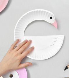 someone is making a paper plate swan craft