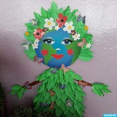 a child's face made out of green leaves and flowers on top of a purple wall