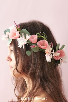 a woman wearing a flower crown with pink flowers and greenery on her head, against a white background