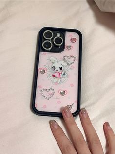 a woman's hand holding a phone case with an elephant on it and two rings