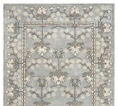 a blue rug with white flowers on the bottom and beige border around it, in an ornate pattern