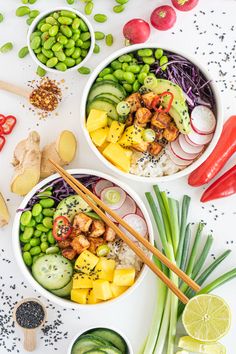 three bowls filled with different types of food on top of a white table next to vegetables and chopsticks